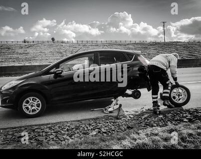 Die Pannenhilfe. Mechaniker Reifenwechsel auf dem Seitenstreifen der Autobahn M90. Schottland. UK. Stockfoto