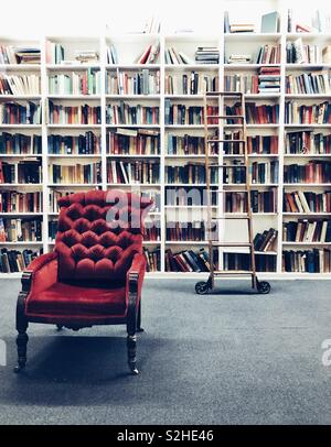 Vintage Style Bibliothek mit rollenden Leiter und roten Stuhl Stockfoto