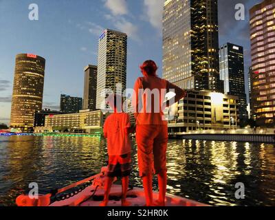 Eine Familie Kreuzfahrten bis das Hillsborough River mit Tampa Riverwalk und Skyline vor Ihnen. Stockfoto