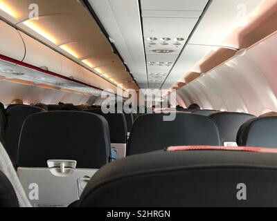 Ein point of view (POV) Perspektive von ein Economy Class Sitz auf eine kommerzielle Fluglinie Flugzeug wird während eines Tages Flug gezeigt. Stockfoto