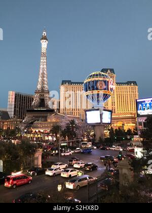 Verkehr in der Dämmerung in Las Vegas mit dem Pariser Hotel im Hintergrund Stockfoto