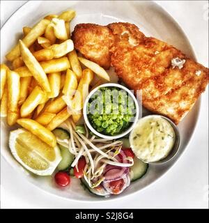 Fisch und Chips mit Erbsenpüree und Salat. Stockfoto
