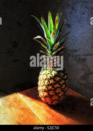 Ananas auf Holztisch mit Sonnenlicht Stockfoto