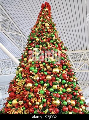 Ein riesiger Weihnachtsbaum mit Rot, Grün und Gold Holiday Ornamenten verziert Stockfoto