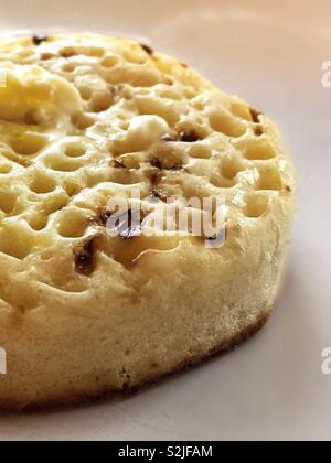 Crumpet zum Frühstück schön und heiß und Buttrig. Perfekte Füllung Start in den Tag getoastete oder gegrillt. Klare und weiche pillowy Brot Lebensmittel Stockfoto