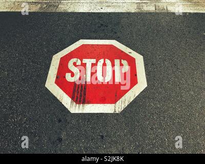 Stop-Schild Straßenmarkierungen mit Bremsspuren in der it Stockfoto