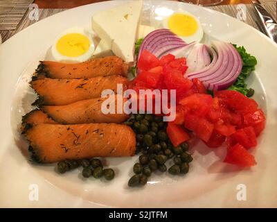 Köstlich leckeren geräucherten Lachs lox-Platte mit roten Zwiebeln, gewürfelt Tomaten, Kapern, und eine perfekt hart gekochtes Ei in die Hälfte geschnitten. Stockfoto