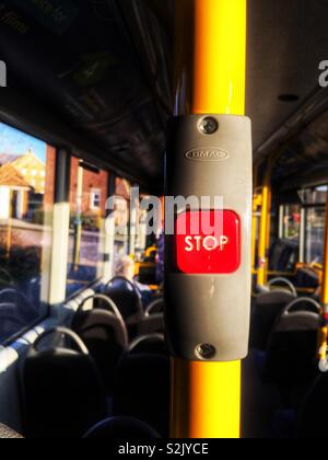 Das Innere eines fast leeren Bus, unter Betonung der Passagier-aktivierte Schaltfläche STOP, rot auf einem gelben Pol. Stockfoto