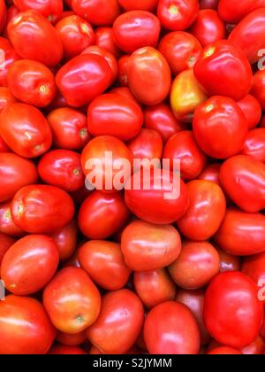 Full Frame von frischen roten reifen Tomaten gestapelt in einem Fach auf der Anzeige und zum Verkauf an die lokale Anbieter produzieren. Stockfoto