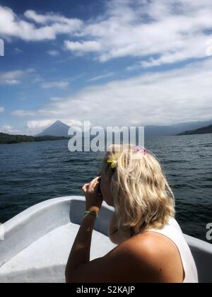 Eine Frau, die Bilder von einem Boot auf See Arenal in Costa Rica. Stockfoto