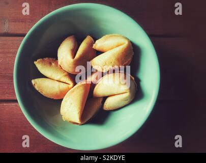 Chinesische Glückskekse in grüner Schale auf Holz- Oberfläche Stockfoto