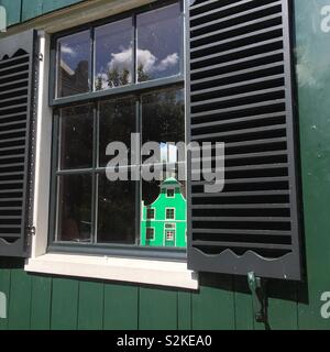 Zaanse Schans traditionelle grüne Holzhaus mit Nachbau miniatur Puppenhaus im Fenster, Niederlande Stockfoto