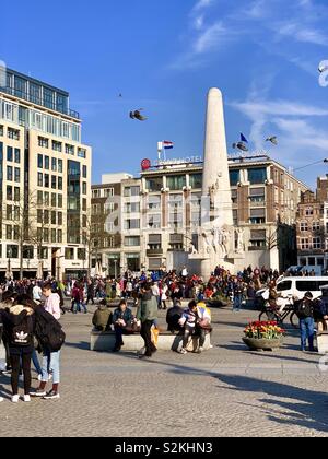 Amsterdam, Niederlande - 9 April 2019: Viele Leute in der Dam Platz auf einem hellen Frühling Nachmittag. Stockfoto