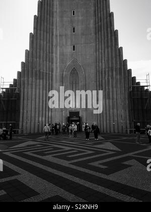 Schwarz-weiß Foto von Exterieur und Plaza mit Menschen die Hallgrímskirkja oder die Kirche von Hallgrímur in Reykjavík, Island. Stockfoto