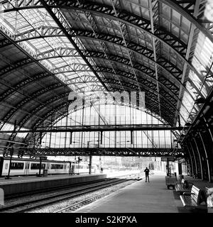 Amsterdam, Niederlande, 12. April 2019: Ein Mann wartet auf einen Zug auf einer verlassenen Plattform an der Central Station. Stockfoto