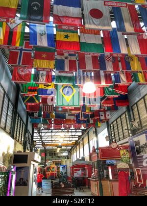 Reihen von internationalen Flaggen am Eingang eines Tram Station in Rio de Janeiro, Brasilien hängen. Stockfoto