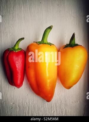 Drei mini Paprika in einem lackierten Holz- Oberfläche Stockfoto