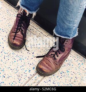 Lila Stiefel auf Londoner U-Bahn. Stockfoto