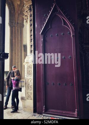 Paar an Ihrem Telefon durch die Türen der Sainte Chapelle in Paris Stockfoto