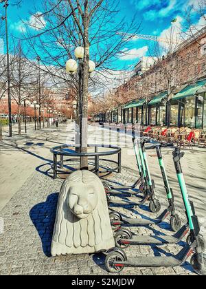 Steinernen Löwen carving Elektroroller und Reihe von Cafés und Terrassen, Kungsträdgården, Stockholm, Schweden, Skandinavien Stockfoto