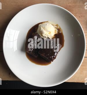 Sticky Toffee Pudding mit Vanilleeis an Diablo's, Carmarthen, Wales. Stockfoto