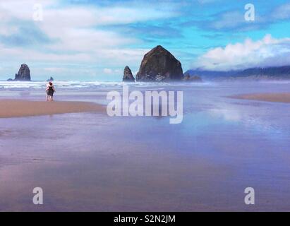 Paar zusammen zu Fuß auf den Strand von Haystack Rock in Cannon Beach Oregon. Stockfoto