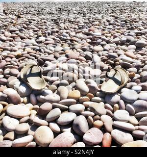 Flip Flops auf Stein Strand Stockfoto