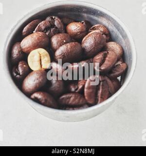 Unter geröstete Kaffeebohne zusammen mit gerösteten Bohnen. Stockfoto