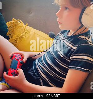 Jungen spielen auf der PS4 Stockfoto