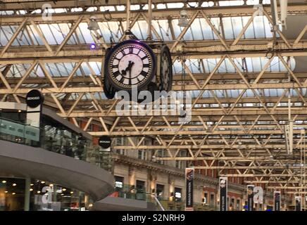 Vierseitige Uhr aus der Sparren in Waterloo Bahnhof, London hängt. Stockfoto