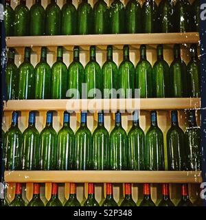 Zehn grünen Flaschen stehend an der Wand Stockfoto