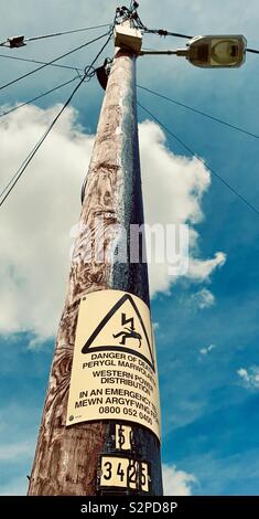 Strommast mit bi-lingual Welsh/English Gefahr des Todes Warnschild Stockfoto