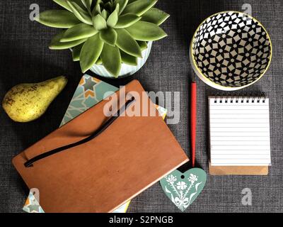 Eines Verfassers Schreibtisch mit Notebook der Reporter und Pflanzen und Früchte Stockfoto