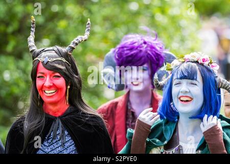 Eine Gruppe von cosplay Mädchen als Lebewesen mit bunten Gesicht Farbe und Perücken zusammen in eine ehrliche portrait Lachen an einem Comic Con Ereignis gekleidet Stockfoto