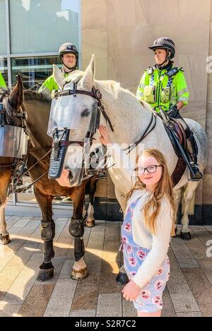 Junge 9 Jahre altes Mädchen petting weißen Polizei Pferd Stockfoto