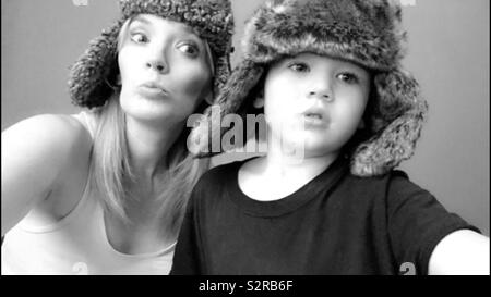 Schwarz-weiß Bild von einer Mutter und ihrem Sohn tragen passende warm fuzzy Hüte für Schwarzweiß-Bild Stockfoto