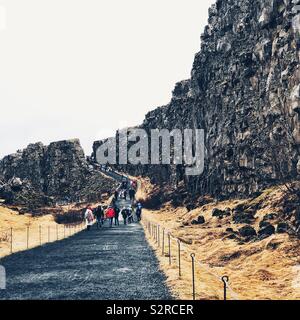 Touristen wandern in Rift Valley zwischen Amerikanischen und eurasischen Kontinentalplatten in Þingvellir, Island Stockfoto