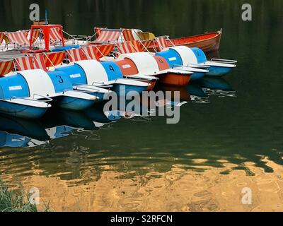 Tretboote in Italien am Lago Misurina mit bunten Reflexionen auf dem Wasser. Stockfoto