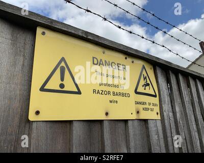 Warnschild durch Stacheldraht geschützt aufbewahren Stockfoto