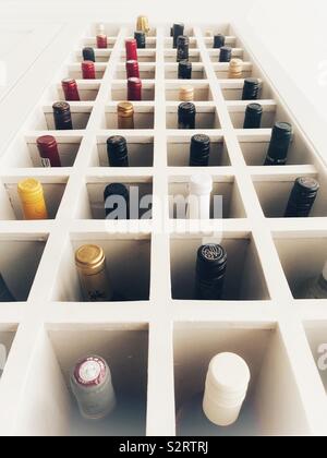 Zu viele Weinflaschen in einer hölzernen Wine Rack. Stockfoto