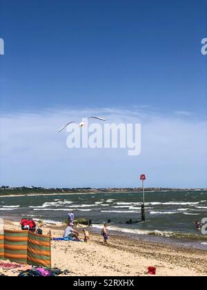 Urlauber auf Avon Strand bei Mudeford, Christchurch, Dorset, Großbritannien an einem heißen Sommertag. Stockfoto