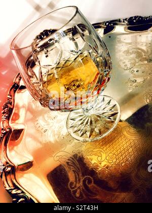 Nahaufnahme von einem Kristall Glas kurze von Cognac auf einer polierten Silber Fach Stockfoto