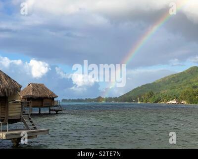 Ein Regenbogen über der Lagune während einer Regendusche in einem Resort auf Moorea Französisch-Polynesien. Stockfoto