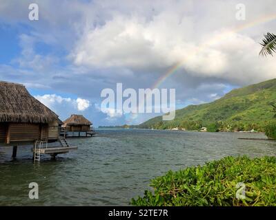 Ein Regenbogen über der Lagune während einer Regendusche in einem Resort auf Moorea Französisch-Polynesien. Stockfoto