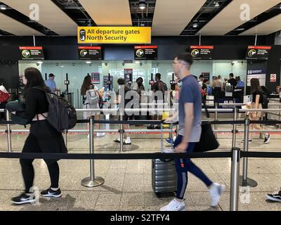 Passagiere der Warteschlange durch die Sicherheitskontrolle am Flughafen Heathrow Terminal 3 zu gehen. Stockfoto