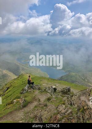 Junge Frau genießt die Aussicht vom Gipfel von Snowdon, Snowdonia (Eryri) Nationalpark, Nordwales. Stockfoto
