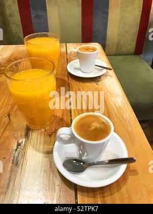 Zwei Tassen Kaffee und zwei Gläsern Orangensaft. Stockfoto
