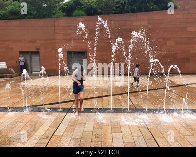 Spielende Kinder im Brunnen an einem heißen Sommertag. Stockfoto