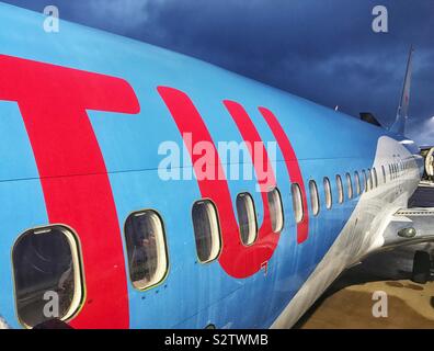 TUI-Logo an der Seite eines Urlaubs Jet am frühen Morgen mit Gewitterwolken Stockfoto