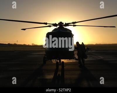 RAF Pilot boarding Lynxx Hubschrauber bei Sonnenaufgang an RAF Odiham, vor der endgültigen Abschied Flug vor der Stilllegung nach 40 Jahren Service. Stockfoto